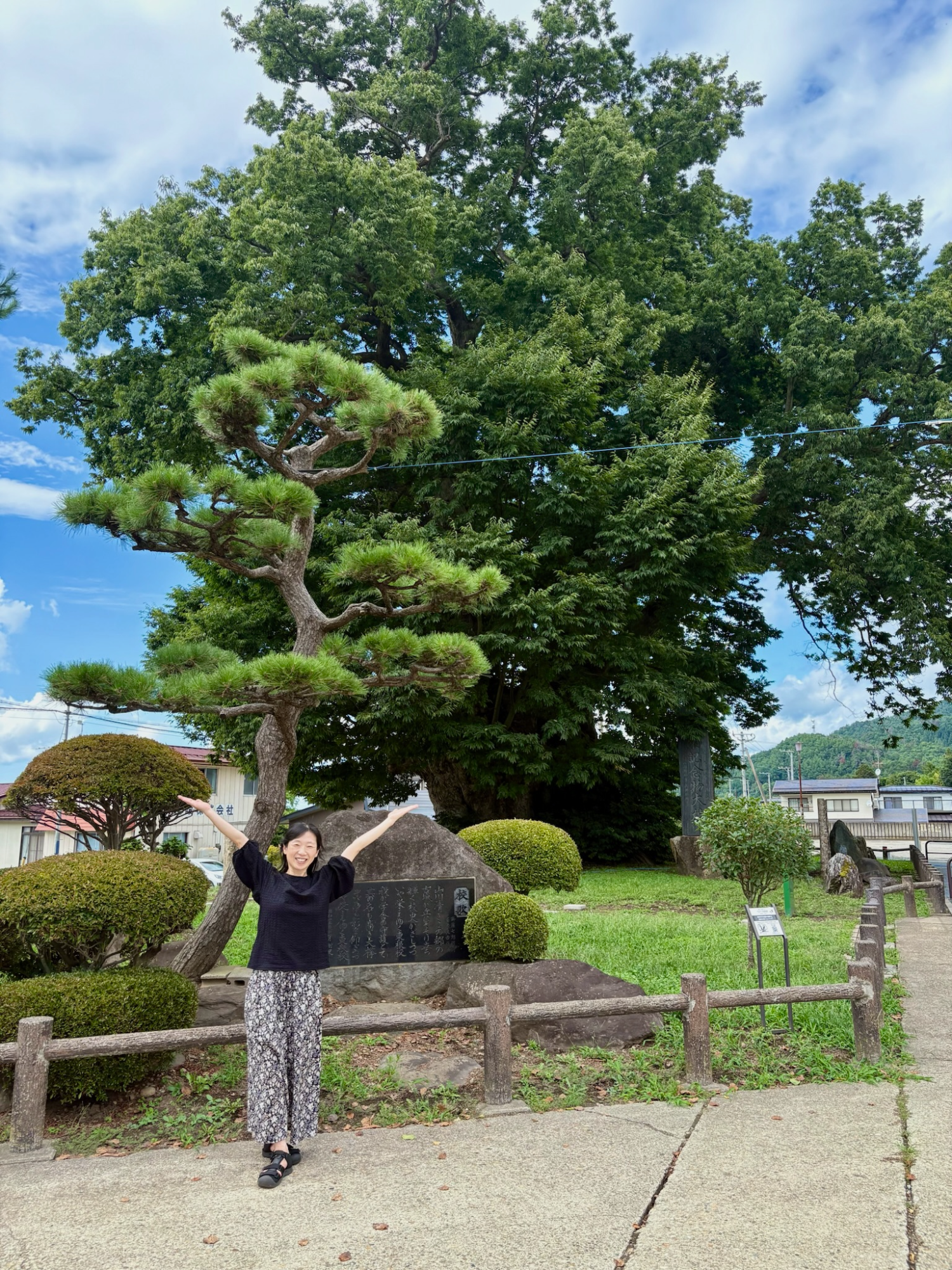 大けやきの前で大きく両手を広げる府川由加里CEO